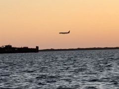 05 Planes fly by going to The Norman Manley International Airport across the Kingston harbour from the waterfront just before sunset Kingston Jamaica